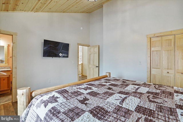 bedroom with ensuite bathroom, wood ceiling, and hardwood / wood-style floors