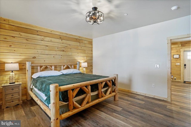 bedroom featuring dark hardwood / wood-style flooring and wood walls