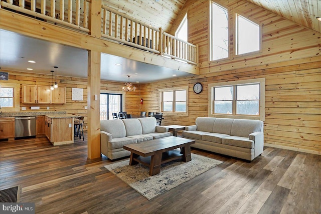 living room with high vaulted ceiling, a notable chandelier, wood ceiling, and wooden walls