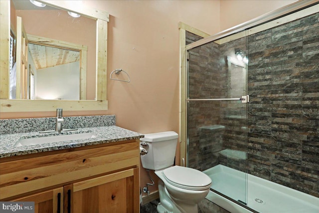 bathroom featuring toilet, an enclosed shower, and vanity