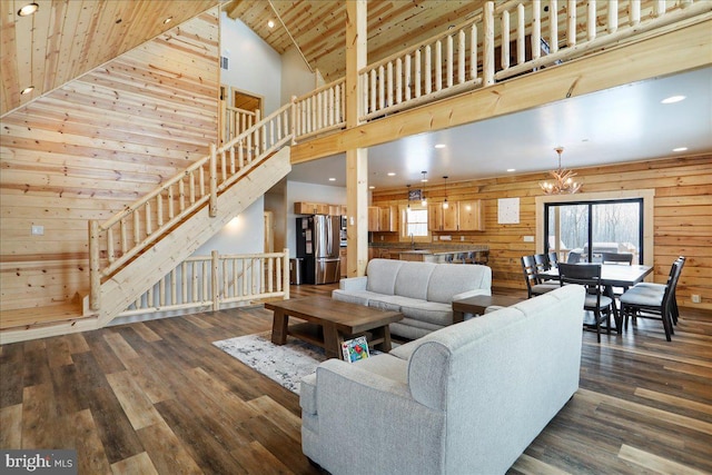 living room featuring wood ceiling, wooden walls, dark hardwood / wood-style floors, a chandelier, and high vaulted ceiling