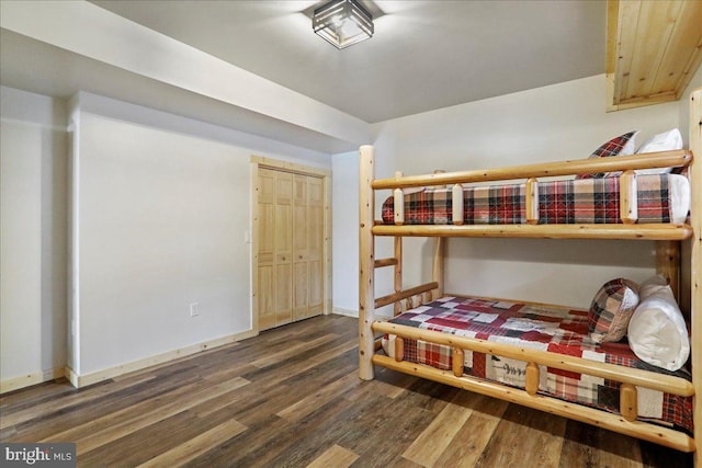 bedroom with dark wood-type flooring and a closet