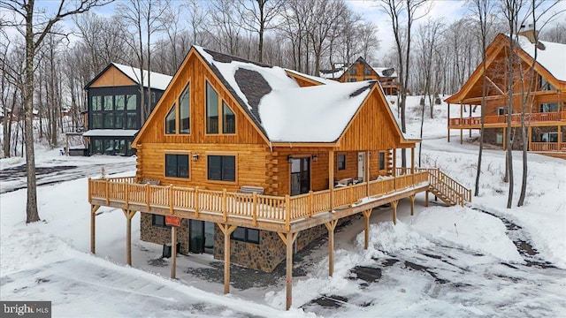 snow covered rear of property featuring a wooden deck