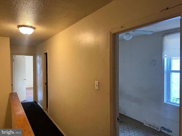 hall featuring a textured ceiling