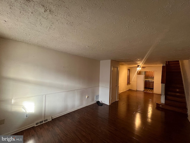 empty room with a textured ceiling and dark hardwood / wood-style flooring