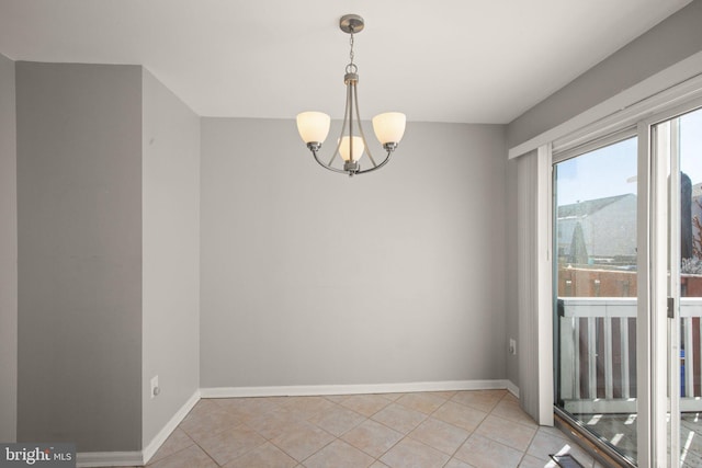 spare room with a notable chandelier and light tile patterned floors