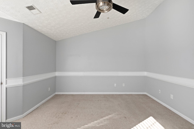 spare room with a textured ceiling, ceiling fan, and light carpet