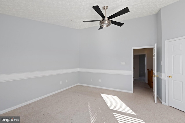 carpeted empty room with a textured ceiling and ceiling fan