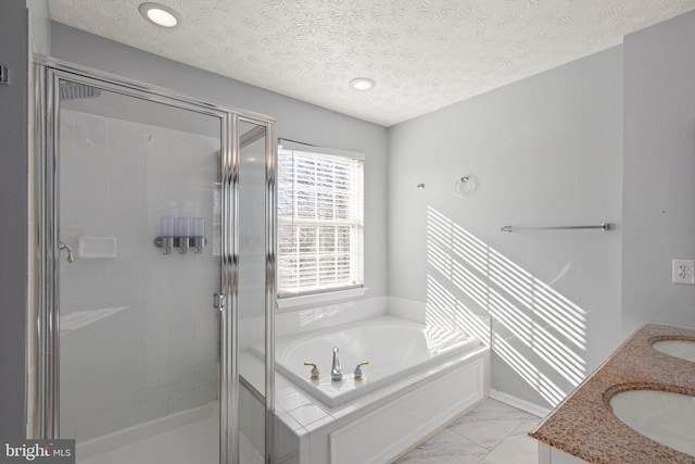 bathroom with shower with separate bathtub, vanity, and a textured ceiling