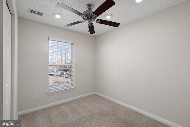 unfurnished room with a healthy amount of sunlight, a textured ceiling, ceiling fan, and carpet flooring