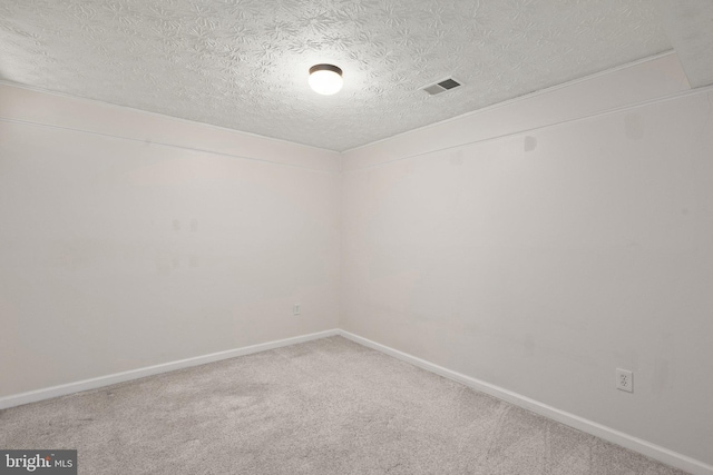 carpeted spare room with a textured ceiling