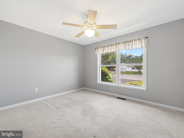 spare room featuring ceiling fan and light colored carpet