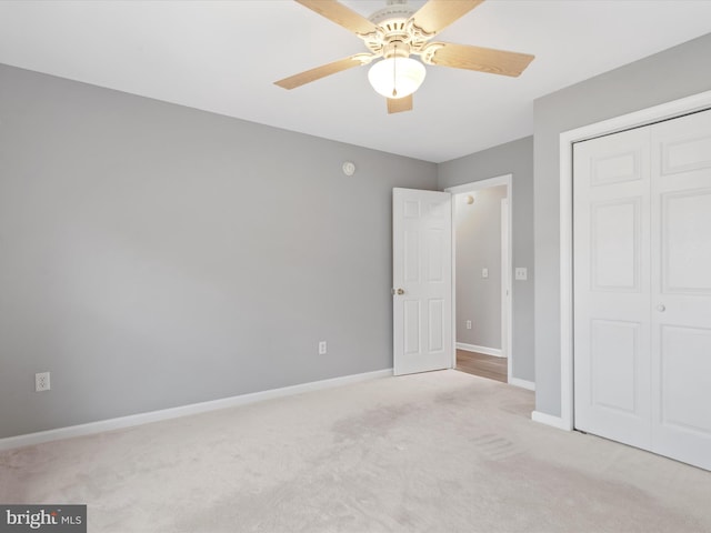 unfurnished bedroom with ceiling fan, a closet, and light carpet