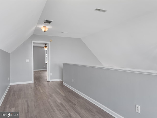 additional living space featuring light hardwood / wood-style floors and vaulted ceiling