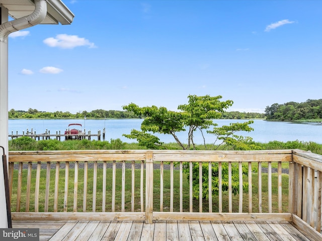 wooden deck featuring a yard, a dock, and a water view