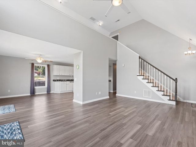 unfurnished living room featuring hardwood / wood-style floors, high vaulted ceiling, and ceiling fan with notable chandelier