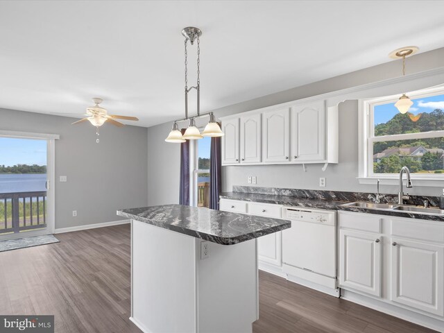 kitchen with white dishwasher, white cabinets, sink, ceiling fan, and a kitchen island