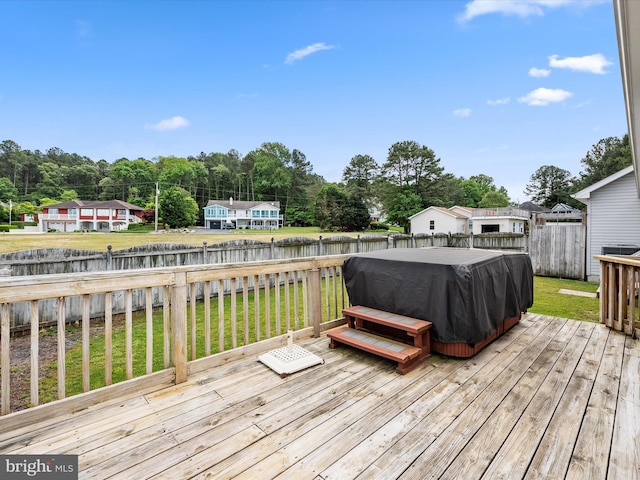 wooden deck with a lawn and a jacuzzi