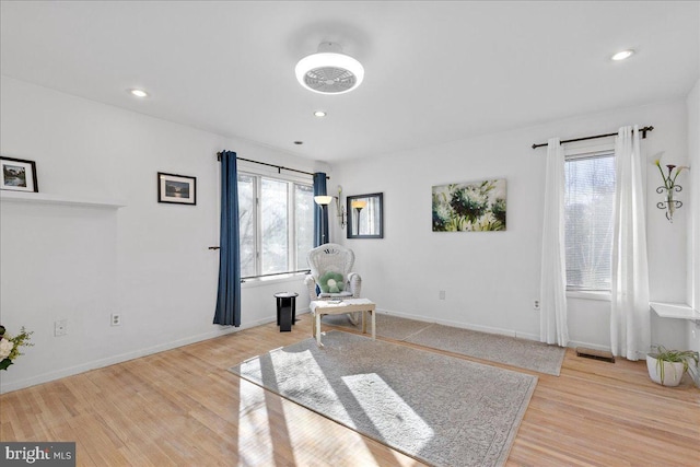 living area with light hardwood / wood-style flooring and a wealth of natural light