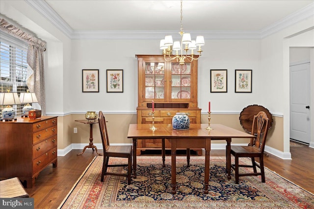 dining space featuring dark hardwood / wood-style flooring, ornamental molding, and a chandelier