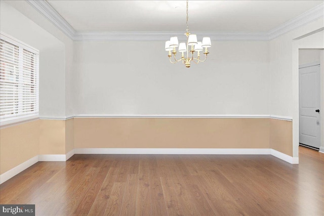 unfurnished room featuring an inviting chandelier, hardwood / wood-style floors, and ornamental molding