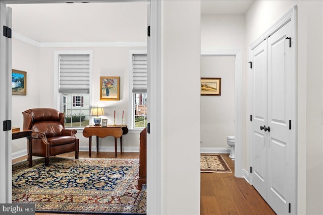 corridor featuring ornamental molding and hardwood / wood-style floors