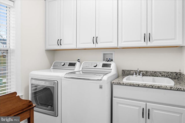 laundry area with cabinets, independent washer and dryer, sink, and a wealth of natural light