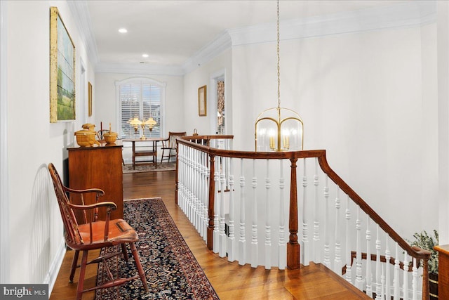 hall featuring hardwood / wood-style flooring, crown molding, and a chandelier