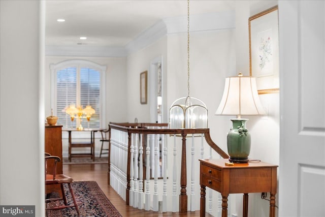 hallway with ornamental molding, a chandelier, and wood-type flooring