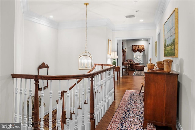 hallway with hardwood / wood-style flooring, crown molding, and a chandelier