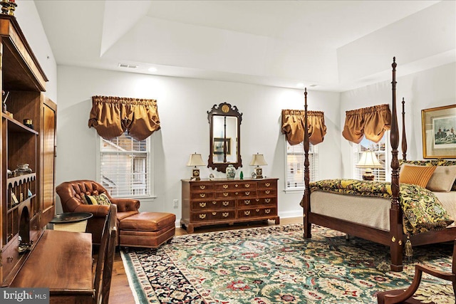 bedroom with a raised ceiling and hardwood / wood-style floors