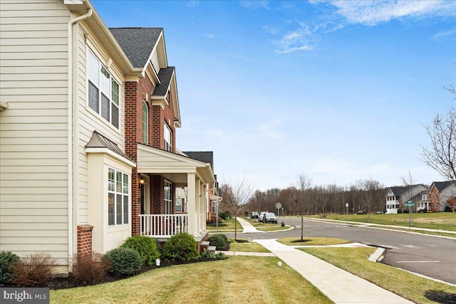 view of side of property featuring a yard and covered porch