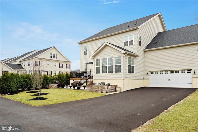 back of house featuring a yard and a garage