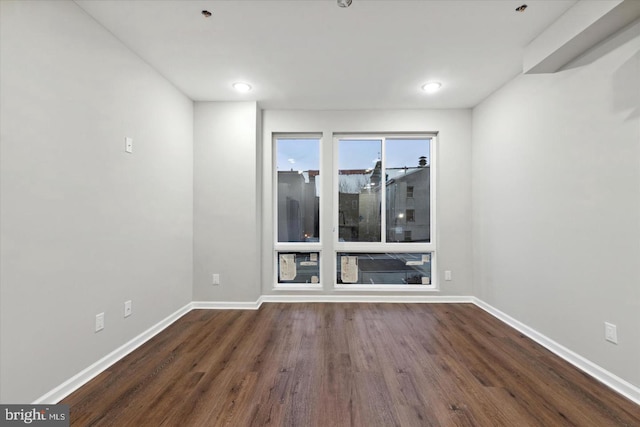 unfurnished room with dark wood-type flooring