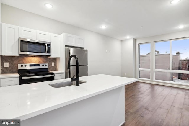 kitchen featuring tasteful backsplash, stainless steel appliances, sink, dark hardwood / wood-style floors, and white cabinetry