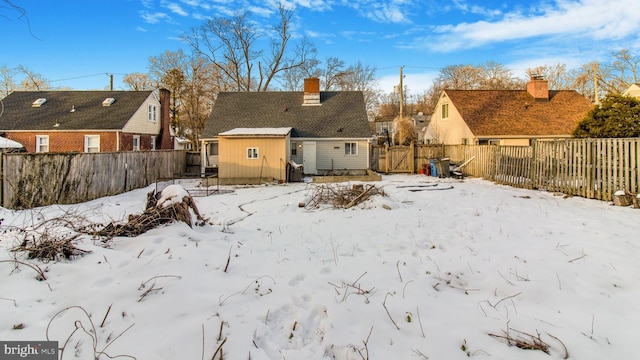 view of snow covered back of property