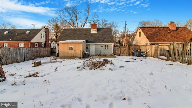 snow covered house with a storage unit