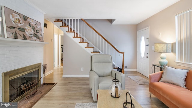 living room with light hardwood / wood-style flooring and a brick fireplace