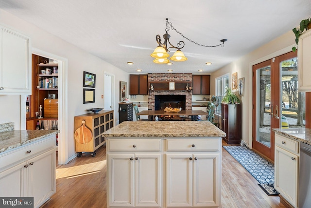 kitchen featuring hanging light fixtures, light stone countertops, a chandelier, and a center island