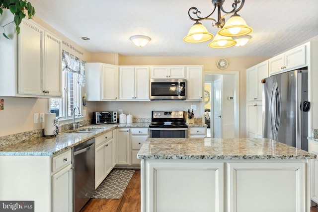 kitchen with white cabinets, a center island, stainless steel appliances, and pendant lighting