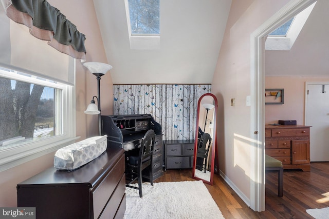 office with vaulted ceiling with skylight and hardwood / wood-style floors