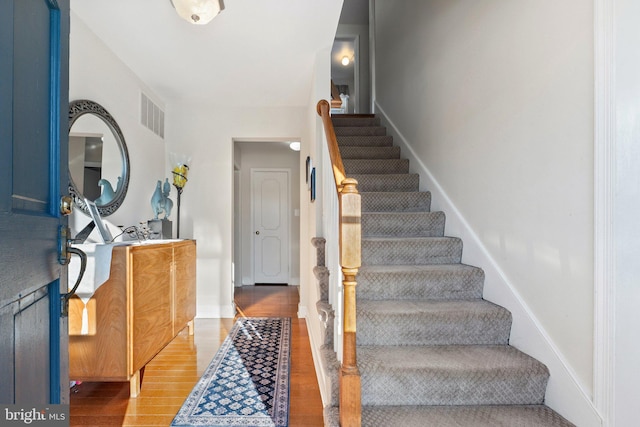 staircase with hardwood / wood-style flooring