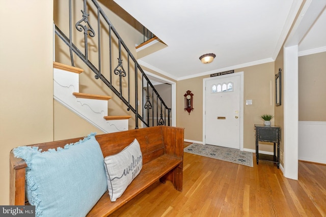 entryway featuring hardwood / wood-style flooring and ornamental molding