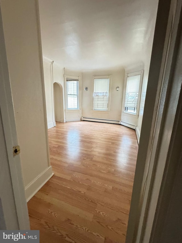106 S Overbrook Ave, Trenton, NJ 08618 - spare room featuring wood finished floors, baseboards, arched walkways, and a baseboard heating unit
