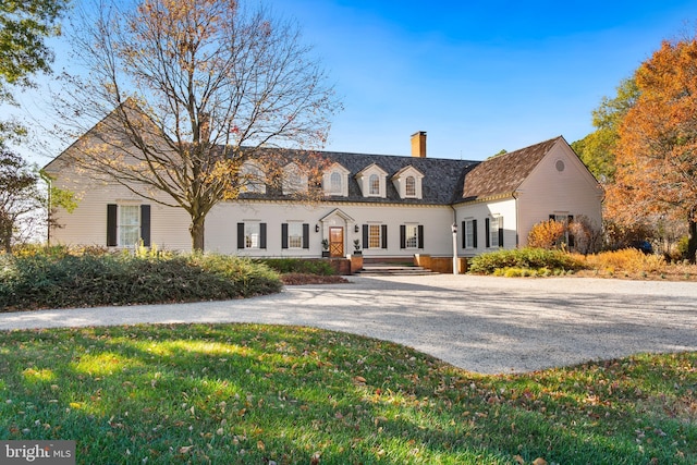 cape cod house with a front yard