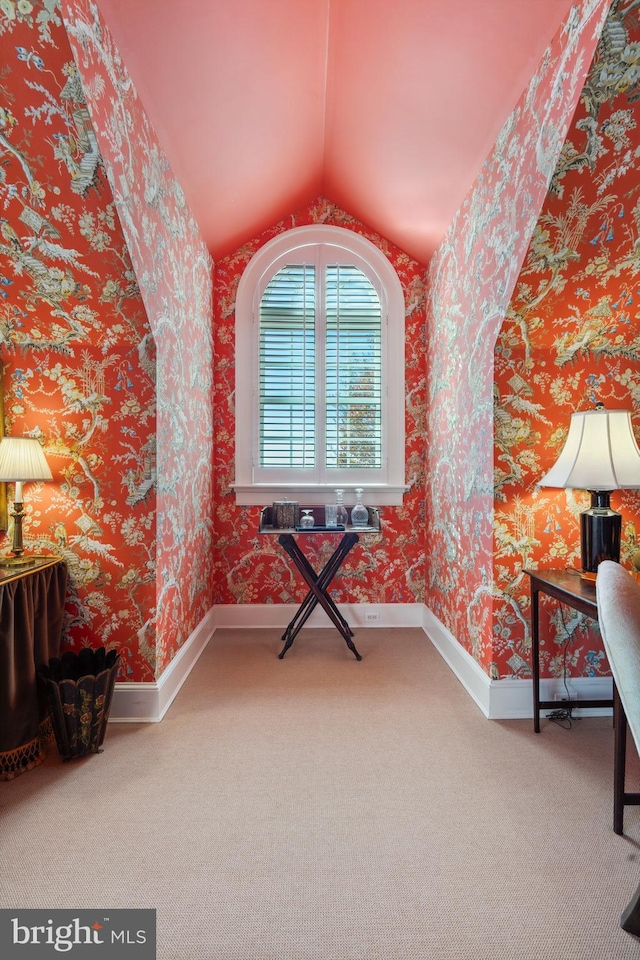 unfurnished room with carpet flooring and vaulted ceiling