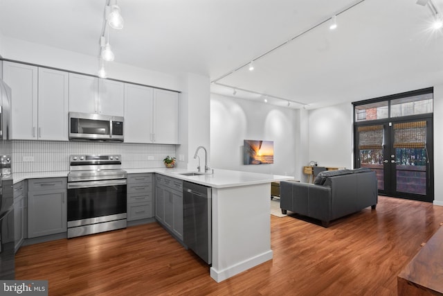 kitchen featuring kitchen peninsula, gray cabinets, sink, and stainless steel appliances