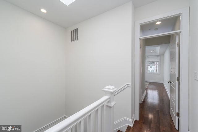 hallway with recessed lighting, visible vents, dark wood-type flooring, an upstairs landing, and baseboards