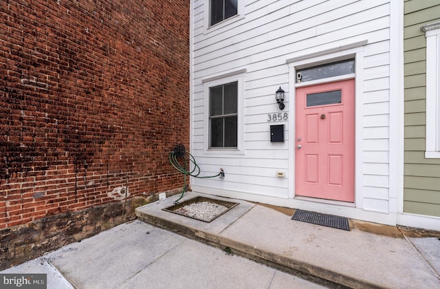 view of exterior entry featuring brick siding