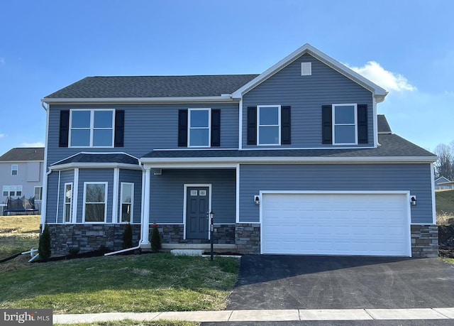 view of front of house featuring a front lawn and a garage